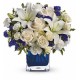 Composición del vidrio de una docena de rosas blancas y las flores azules