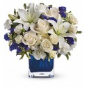 Composition de verre d'une douzaine de roses blanches et de fleurs bleues