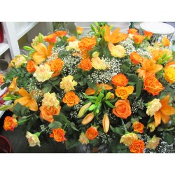 Compoziția funerare cu flori de tonuri de roșu și portocaliu